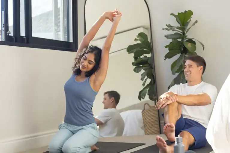 Yoga Anfänger Tipps – Zwei Personen üben entspannt Yoga auf Matten in einem hellen Raum zuhause
