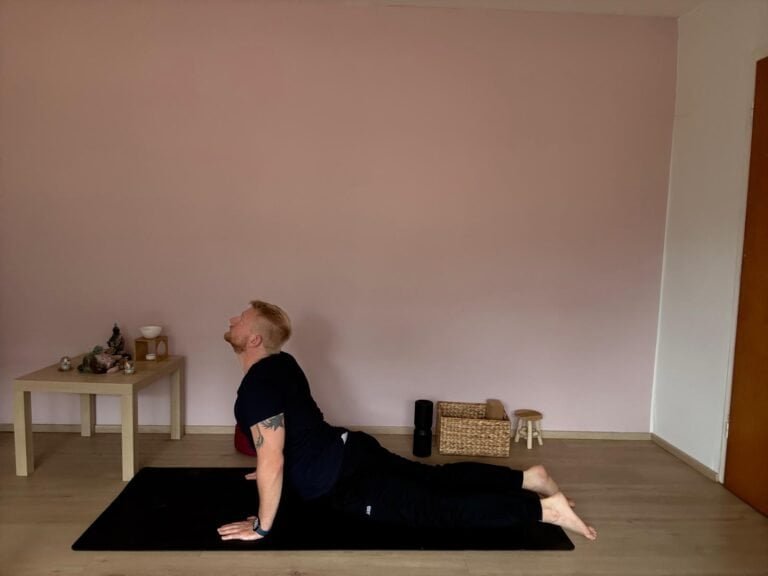 Mann macht Yoga Anfänger Übung Kobra (Bhujangasana) zur Stärkung des Rückens und Öffnung des Brustkorbs.