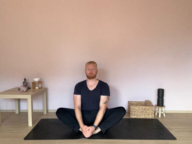 oga Übung Schmetterling (Baddha Konasana) – Mann sitzt auf Yogamatte mit aufgerichtetem Rücken und zusammengelegten Fußsohlen. Sanfte Hüftöffnung und Dehnung für Yoga Anfänger.