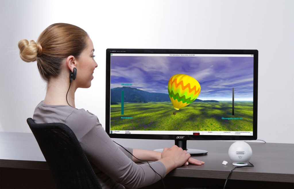 Frau trainiert mit einem Biofeedback-System am Computer, um durch Atemübungen und visuelle Rückmeldung den Vagusnerv zu beruhigen. Auf dem Bildschirm ist ein Heißluftballon zu sehen, der die Atmung visualisiert und das Nervensystem in Balance bringt.