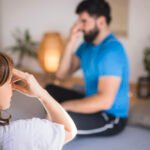 Mann und Frau üben Achtsamkeits-Breathwork mit Hand an der Stirn – Atemübungen für Entspannung und gezieltes Breathwork zur mentalen und körperlichen Entlastung.