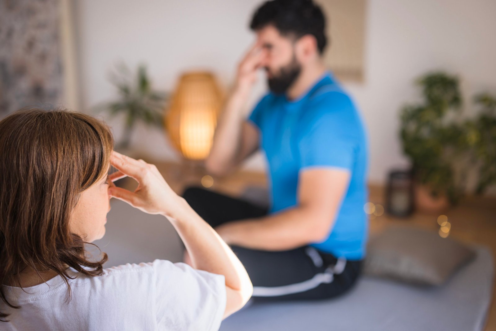 Mann und Frau üben Achtsamkeits-Breathwork mit Hand an der Stirn – Atemübungen für Entspannung und gezieltes Breathwork zur mentalen und körperlichen Entlastung.