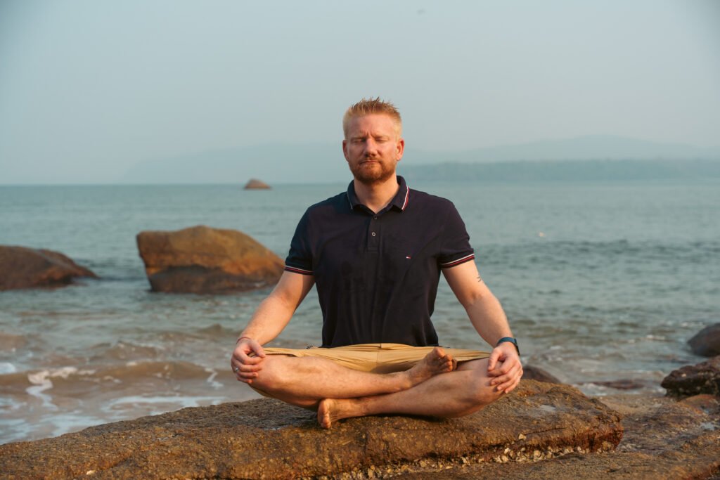 Meditation am Strand in Goa während eines Yoga Retreats in Goa, Indien