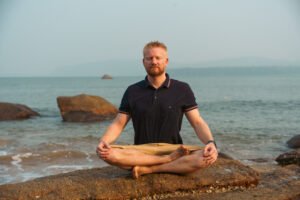 Meditation am Strand in Goa während eines Yoga Retreats in Goa, Indien