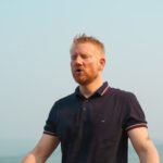 Mann praktiziert eine breathwork session am Meer zur Regulierung des Nervensystems und zur Förderung von innerer Balance
