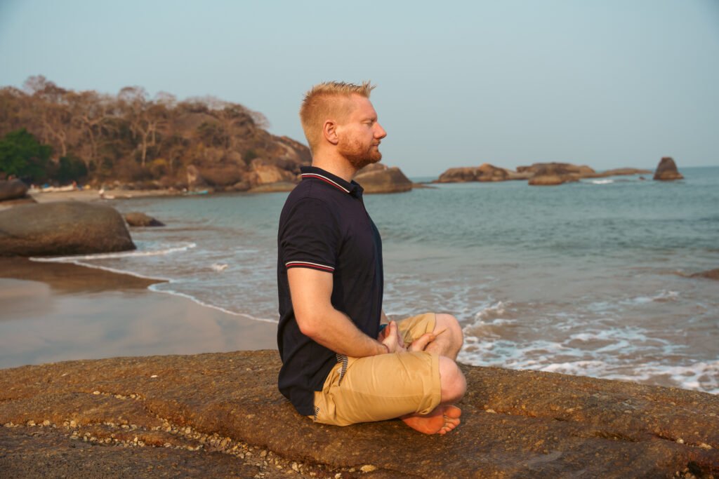 David Train – Resilienz Coach und Breathwork Coach meditiert am Strand in Goa, Indien