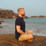 David Train – Resilienz Coach und Breathwork Coach meditiert am Strand in Goa, Indien