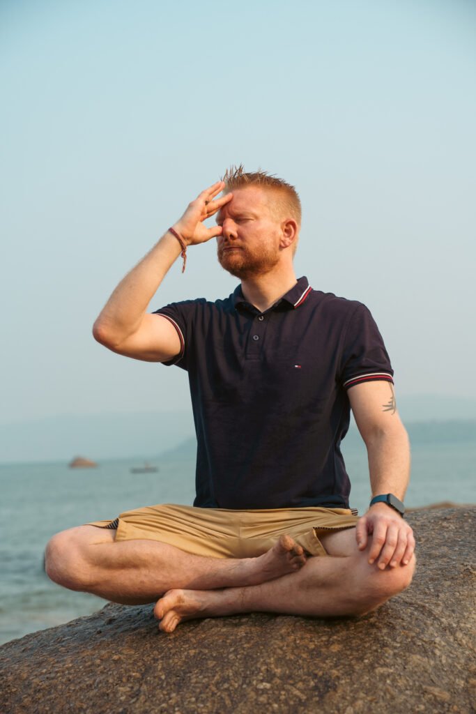 Meditierende Person praktiziert Pranayama Atmung am Meer – Beispiel für eine Breathwork Session mit bewusster Atemtechnik aus dem Yoga.