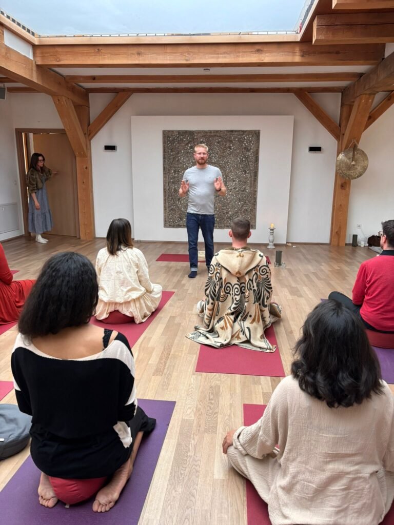 Psychedelic Breath Teacher Training mit Teilnehmern in einer praktischen Breathwork-Ausbildung. Der Trainer leitet eine Gruppe durch Atemübungen, Meditation und bewusstseinsverändernde Atemtechniken in einem Seminarraum an.